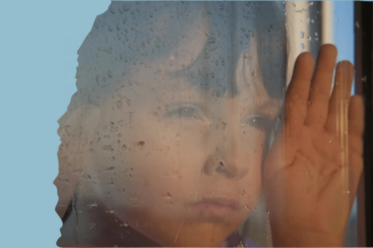 Kuvituskuva kyselylle, kuvassa surullinen lapsi sateisen ikkunan takana.