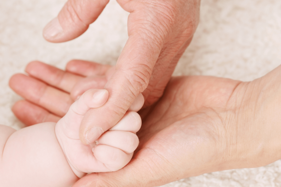 Kolmen sukupolven kädet yhdessä.