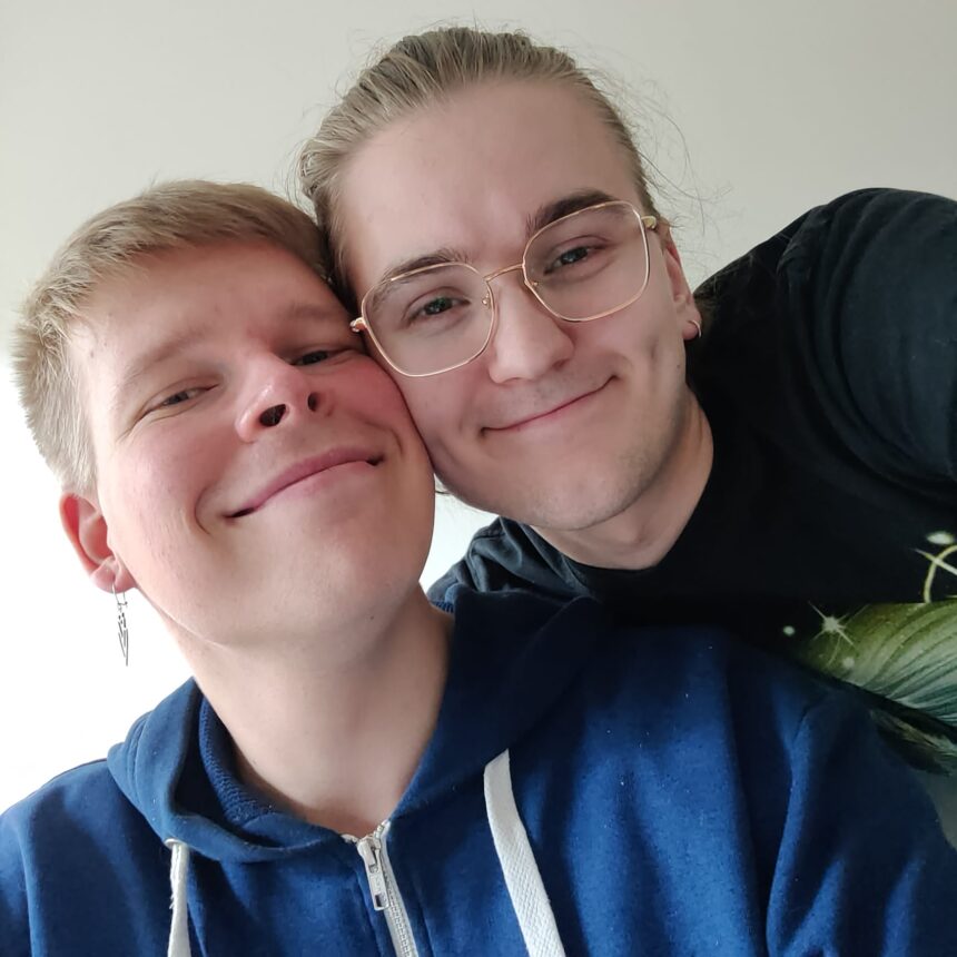 Kaksi aikuista vierekkäin hymyilevinä.