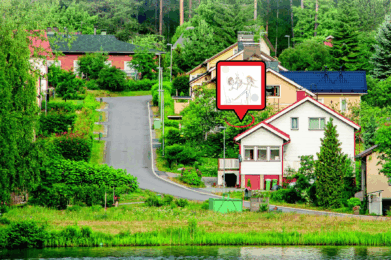 Vehreä omakotitaloalue, jonka halki johtaa tie.