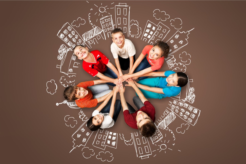 Lapsia piirissä kädet kädessä.