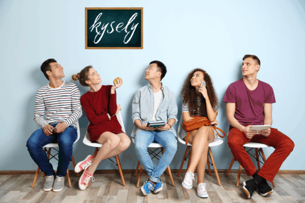 Viisi nuorta istuu penkillä ja katsovat yläpuolella olevaa liitutaulua, jossa lukee sana Kysely.