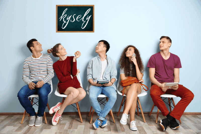 Viisi nuorta istuu penkillä ja katsovat yläpuolella olevaa liitutaulua, jossa lukee sana Kysely.